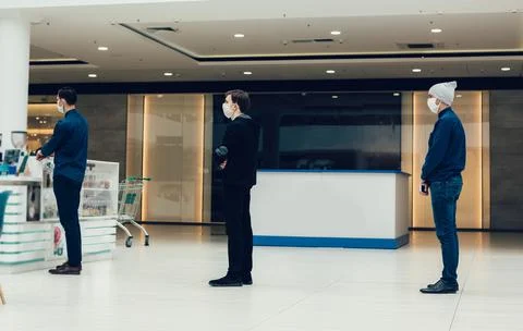 Shoppers in protective masks standing in a queue in a supermarket Stock Photos