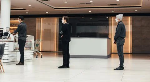 Shoppers in protective masks standing in a queue in a supermarket Foto stock