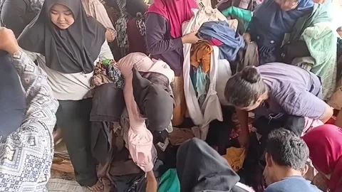 Shoppers Thrifting and Sorting Thrift Apparel in Outdoor Bazaar Видео 347102260