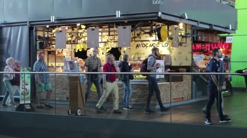 Shoppers tourists walk about inside a food court market. Stock Footage 169090063