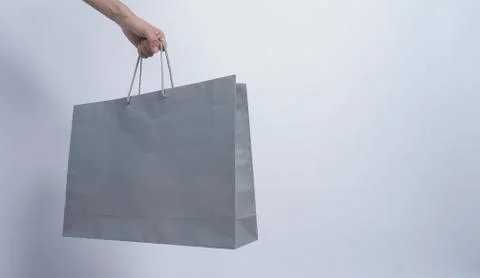 Shopping bag grey color hold on woman arm and white background Stock-Fotos
