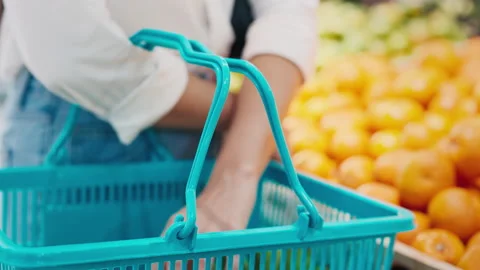 Shopping With a Blue Basket While Selecting Fresh Fruits in a Grocery Store Stock Footage 303737209