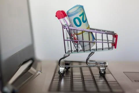 Shopping cart with banknotes on computer keyboard. Online shopping concept Stock Photos