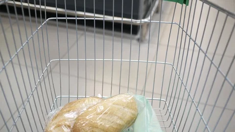 Shopping cart with bread moving through supermarket Stock Footage 128998484