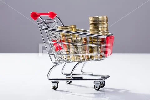 Shopping Cart Filled With Stacked Coins Stock Photos