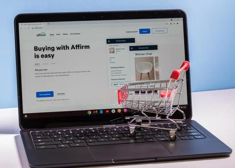 Shopping cart in front of computer screen for Affirm buy now pay later app Stock Photos