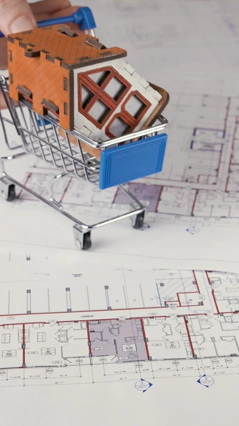 A shopping cart with a house is moving across a blueprint in verical Stock Footage 281367341