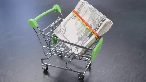 Shopping Cart With a Large Stack of Money Inside 動画素材 111671143
