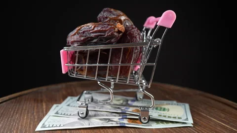 Shopping cart on wheels with dates fruit and american 100 dollar bills, rotates Stock Footage 292542712