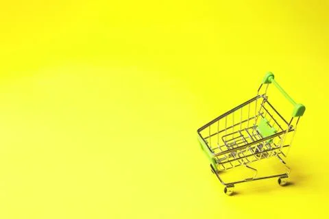 Shopping cart on yellow background. Stock Photos
