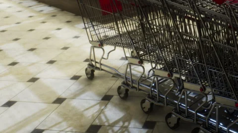 Shopping carts lined up in a retail store with tiled flooring Stock Footage 343574295