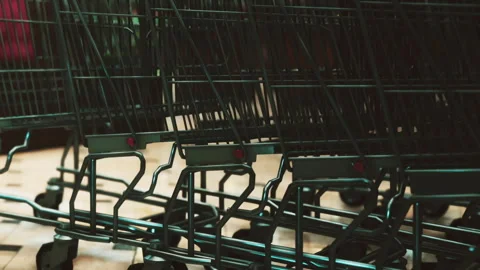Shopping carts lined up in a store with wheels on shiny tile floor Stock Footage 344965118