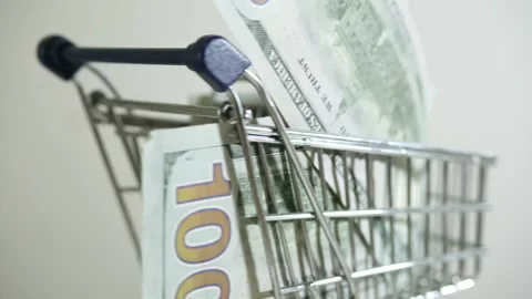Shopping chart with 100 usd bills note on white background Stock Footage 273804310