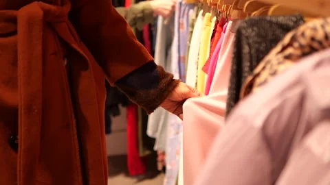 Shopping for clothes in a store with many options in daylight Stock Footage 345953226