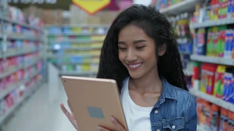 Shopping concepts of 4k Resolution. A young woman using a tablet to search fo Stock Footage 149010637