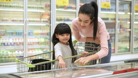 Shopping concepts. Mother and daughter are choosing to buy ice cream in the f Stock Footage