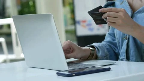 Shopping online with computer while sitting in the kitchen at home involved i Stock Footage 265929181
