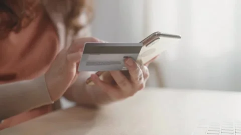 Shopping online with computer while sitting in the kitchen at home involved i Stock Footage 265929945