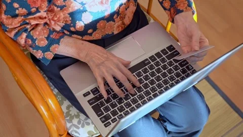 Shopping online with computer while sitting in the kitchen at home involved i Stock Footage 265932415