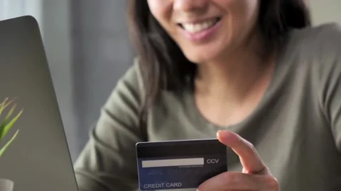 Shopping online with computer while sitting in the kitchen at home involved i Stock Footage 265932558