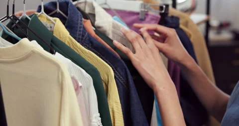 Shopping, rack and hands in store with clothes, garment choice and decision in Stock Footage 345655397