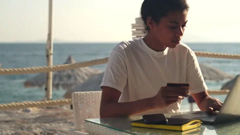 Shopping time. Young mixed race woman making online purchases using her laptop Stock Footage 149437535
