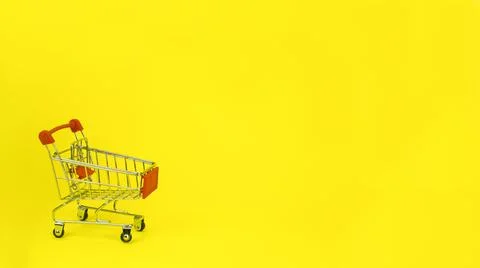 Shopping trolley, cart empty on yellow spot. Promotions, sales, shopping Stock Photos