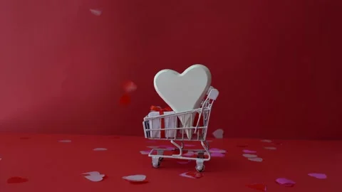 Shopping trolley with gift boxes on red. St. Valentine's Day shopping and sale Stock Footage 167934138