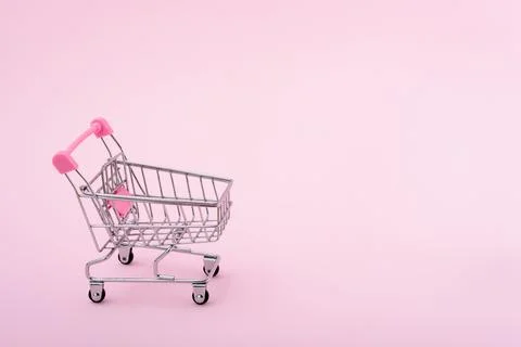 Shopping trolley on pink background Stock Photos