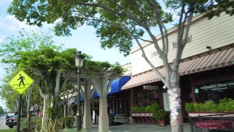 Shops and car parked on the side of the street Stock Footage 83184782