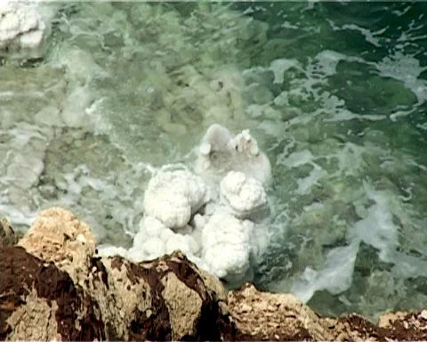 Shore of Dead Sea from Jordan side. Rocks are covered with white salt crystals Stock Footage 120777228