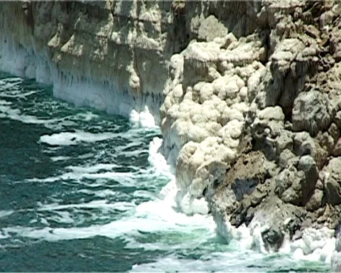 Shore of Dead Sea from Jordan side. Rocks are covered with white salt crystals Stock Footage 121136098