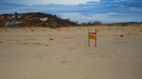 Shore of the sea or ocean with not very clean sand. Cloudy sky in the backdrop. Stock Footage 333412669
