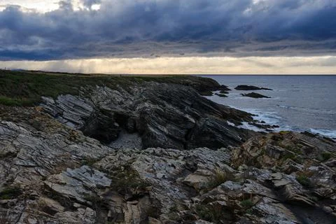 Shoreline with cliffs and dramatic cloudy sky in Galicia, Spain Stock Photos