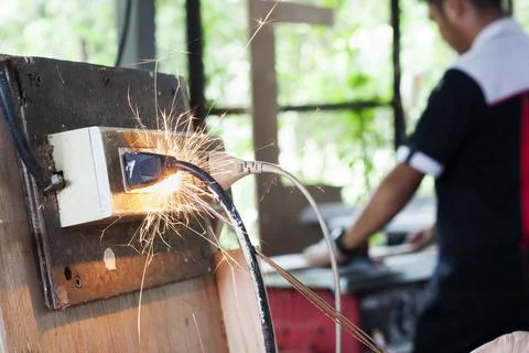 A short circuit causes a spark at the plug. Using non-standard power outlets  Stock Photos