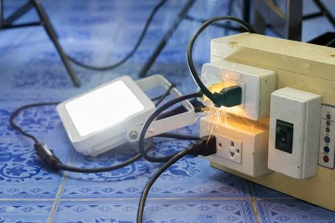 Short circuit, causing a spark to the plug. Using a non-standard power plug O Fotos de archivo