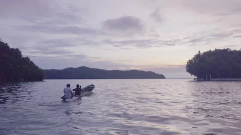 Short Clip Small Boat Rowing on Calm Tropical Sea at Sunset in Kei Islands Vídeos de archivo 333080188