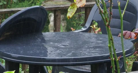 Short full HD 4K video clip of heavy rain falling on a black plastic table in a Stock Footage 269685098