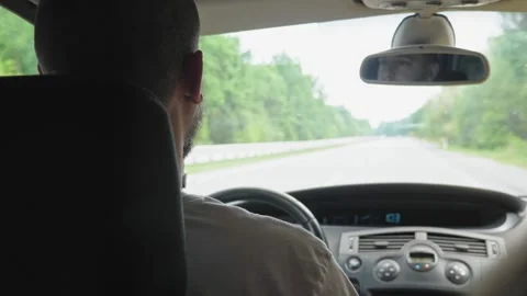 A short-haired, bearded man drives a car along a highway outside the city. A man 스톡 동영상 220462897