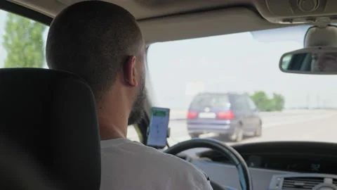 A short-haired, bearded man drives a car along a highway outside the city. A man Stock-Footage 220520968