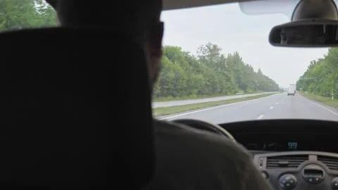 A short-haired, bearded man drives a car along a highway outside the city. A man Video stock 221796341