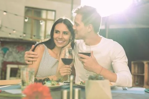 Short-haired young man gently kissing his appealing girlfriend Stock Photos