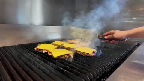 Short Order Cook Grilling Bacon Cheeseburgers at a Classic Roadside Diner Stock Footage 337938858