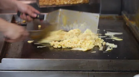 Short order cook making scrambled eggs on a griddle at diner 動画素材 48131125