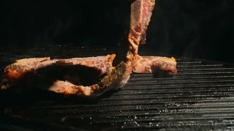 Short ribs steak placed on cast iron grill slow motion Stock Footage 146931092