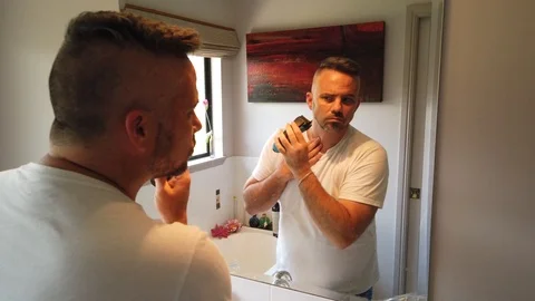 Short slow motion clip of man using an electric razor to put some clean Stock Footage 121870342