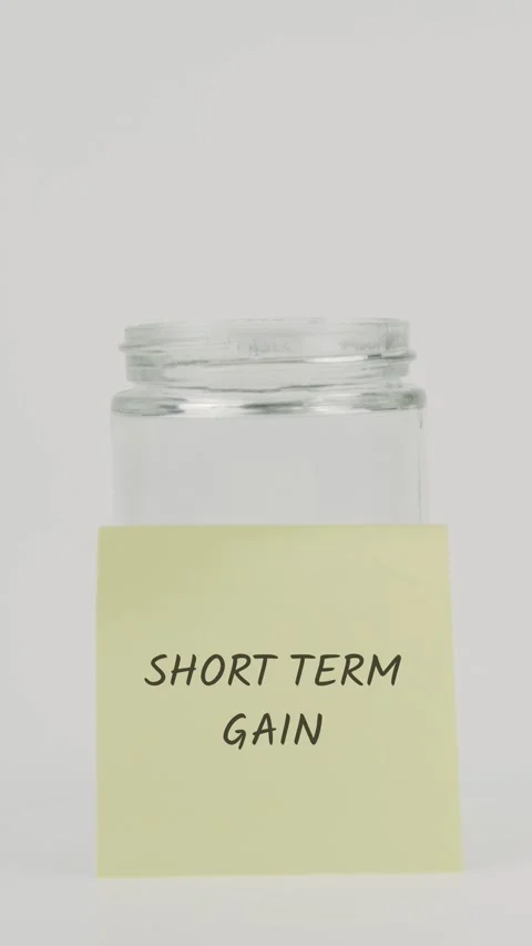 Short term gain text or word on yellow sticky note attached to glass jar Stock Footage 311786168