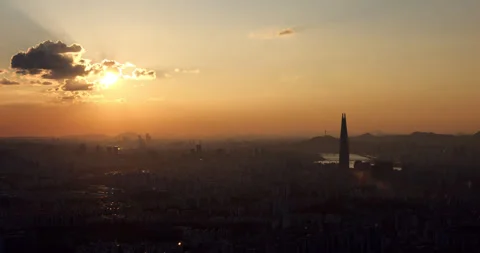 Short time-lapse of sun behind clouds and silhouetted Seoul panorama Stock Footage 295055962