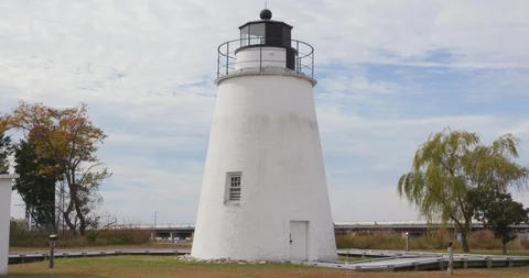 Short White Lighthouse Along River Under Blue Sky Stock Footage 119001330