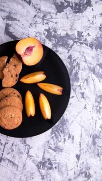 Shortbread and plum sliced on a black plate Stock Photos